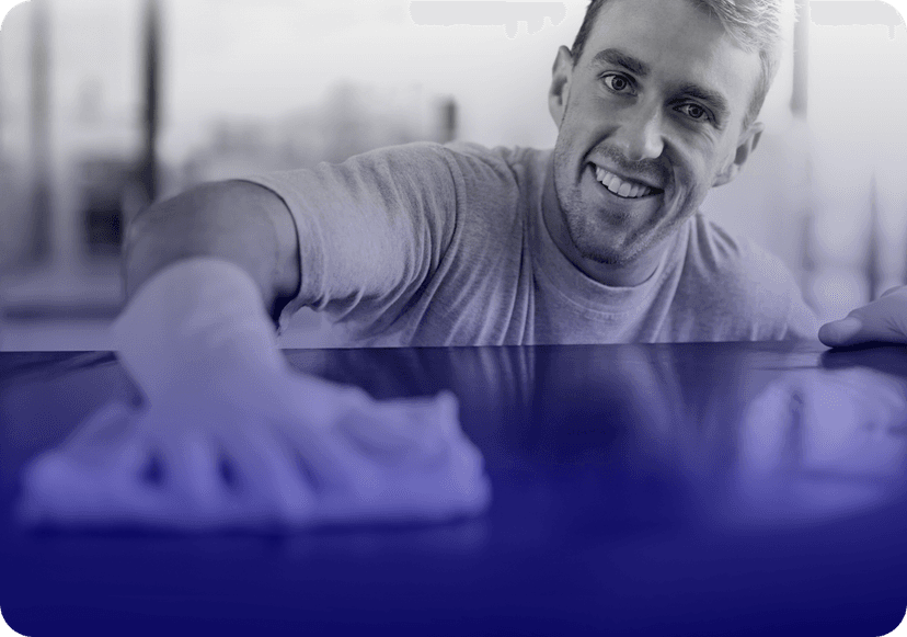Smiling cleaning professional wiping a surface with a cloth